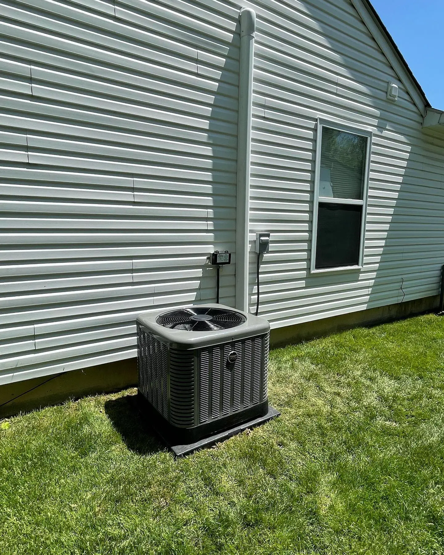 Polley's Perfect Seasons technician working on an outdoor AC unit in a Plainfield, IN backyard