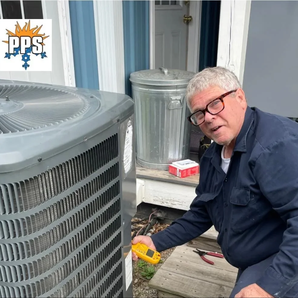 Polley's Perfect Seasons technician performing a multimeter diagnostic on an outdoor AC condenser in Plainfield, IN