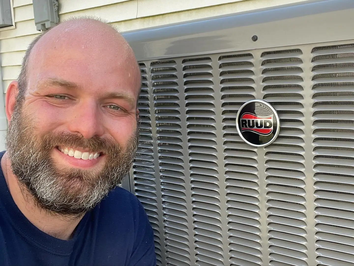 Polley's Perfect Seasons technician servicing a Ruud outdoor AC unit at a Plainfield, IN home