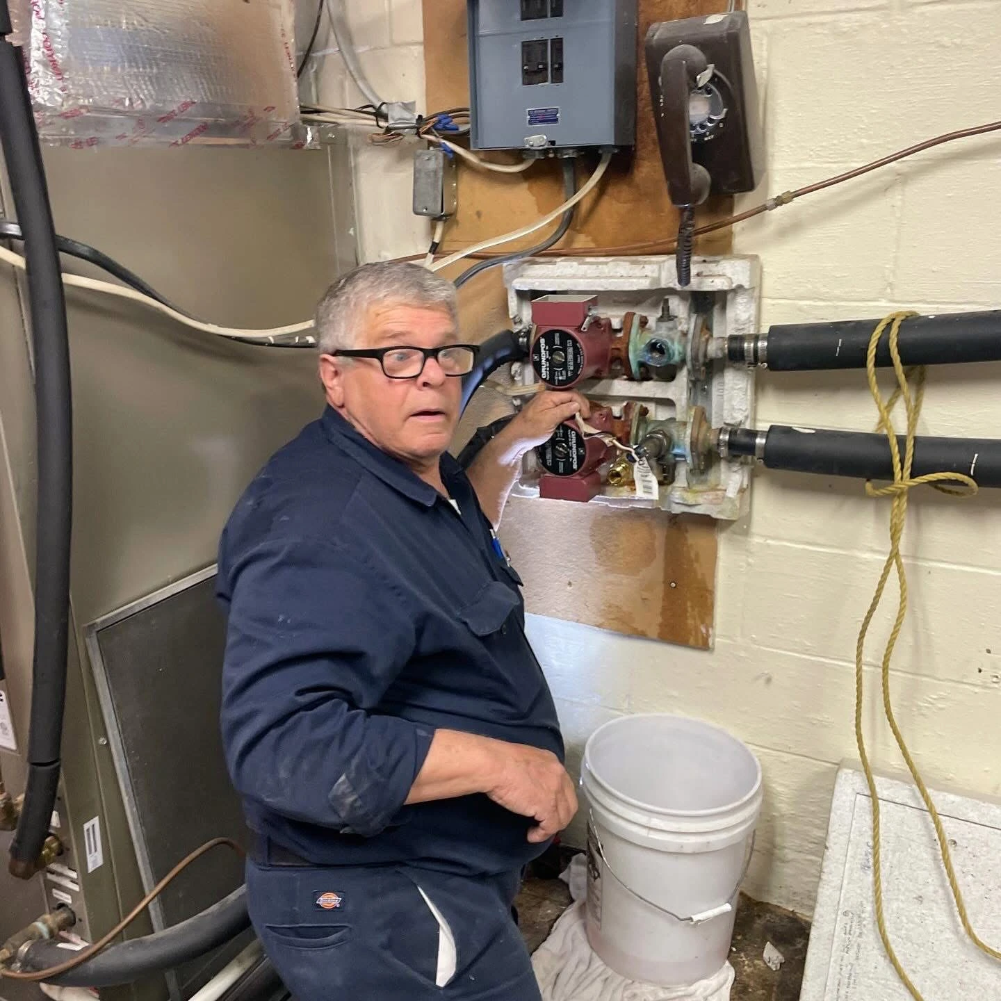 Polley's Perfect Seasons technician inspecting boiler circulator pumps in an older Danville, IN home
