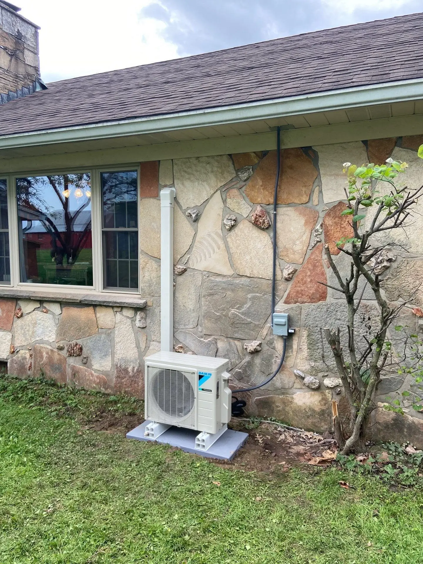 Daikin ductless mini split outdoor unit installed at a stone home in Avon, Indiana