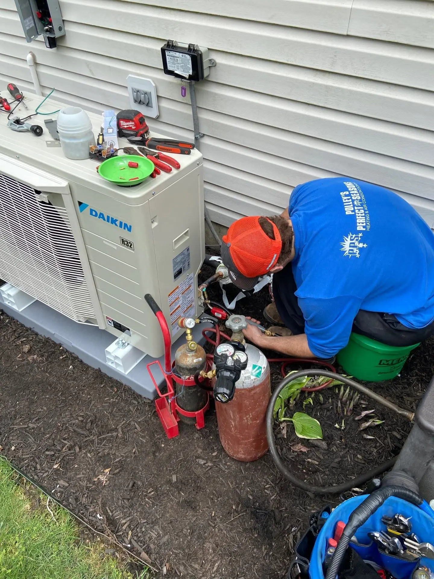 Polley's Perfect Seasons technician brazing and connecting refrigerant lines at a Daikin R32 ductless outdoor unit in Avon, Indiana