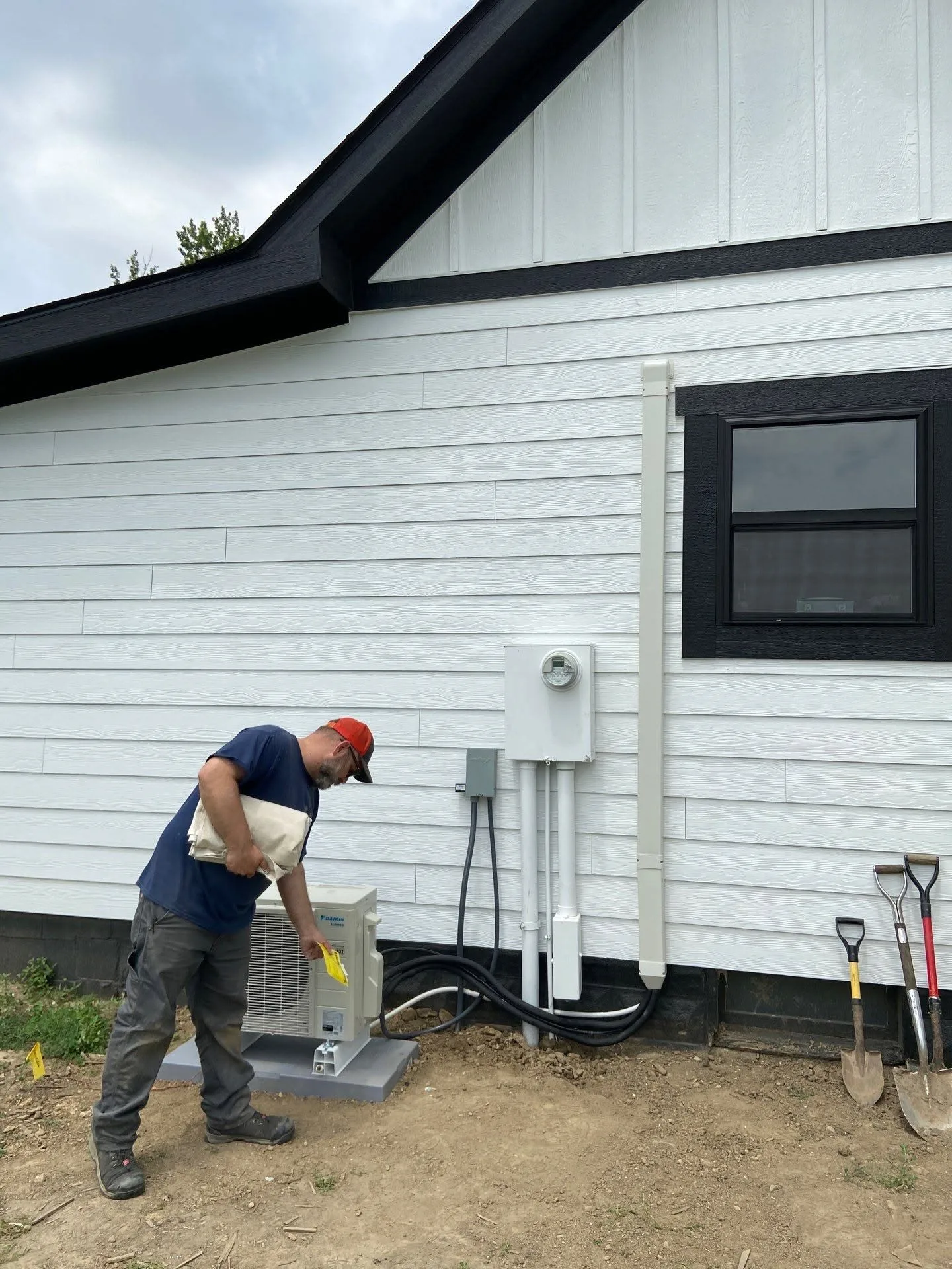 Polley's Perfect Seasons technician checking a newly installed Daikin ductless outdoor unit at a home in Avon, Indiana