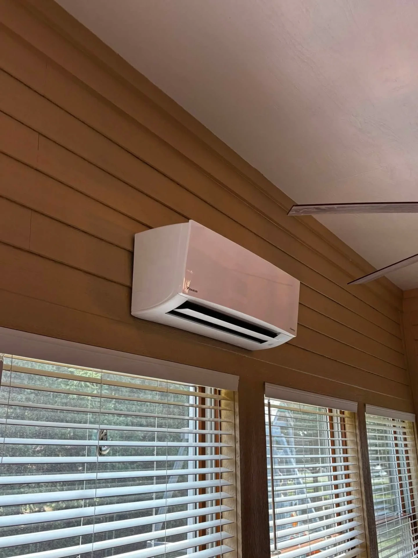 Wall mounted Daikin ductless mini split indoor head installed high on the wall of a sunroom in Avon, Indiana