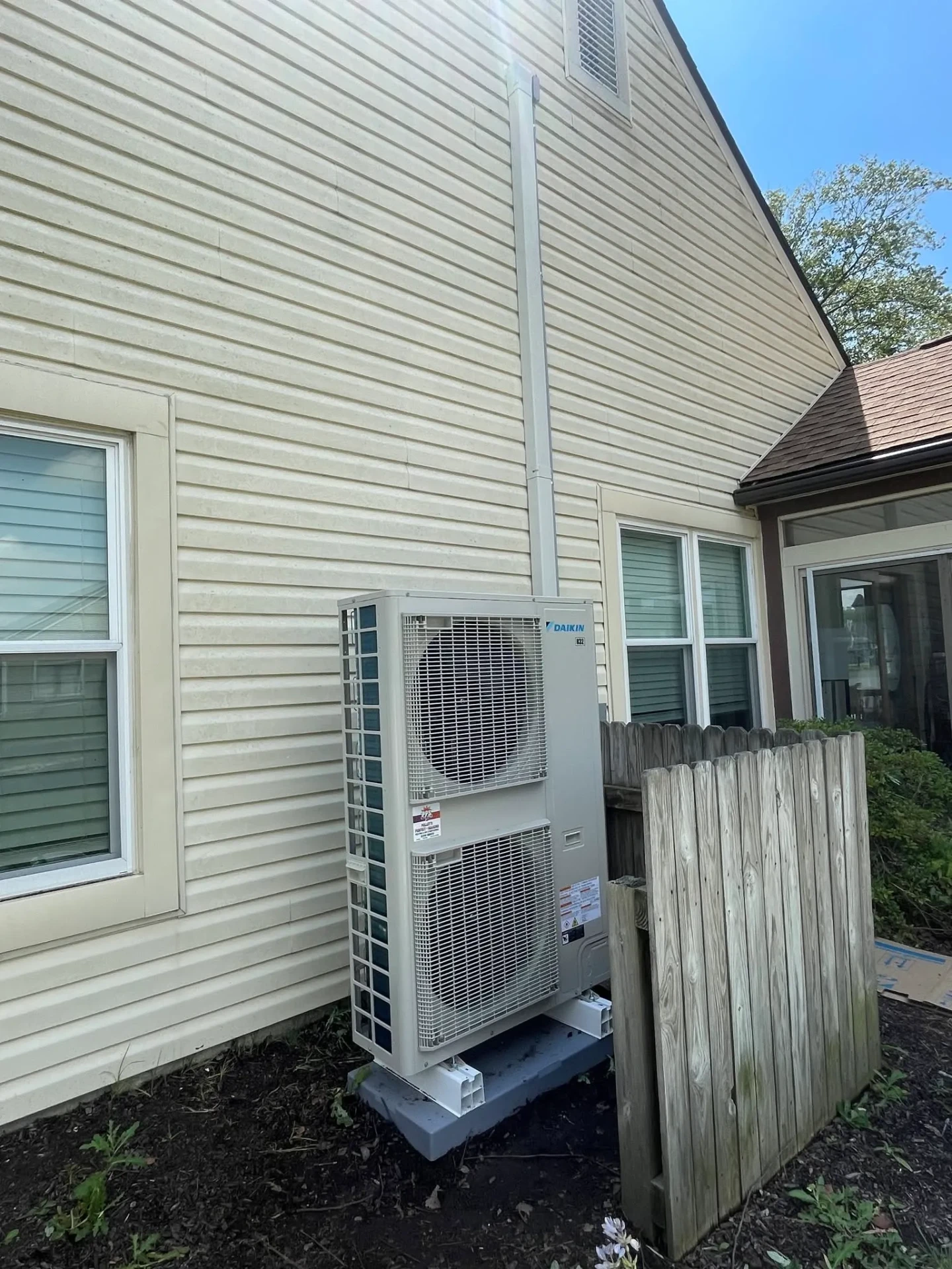 Multi-zone Daikin ductless mini split outdoor condenser installed beside a two story home in Avon, Indiana