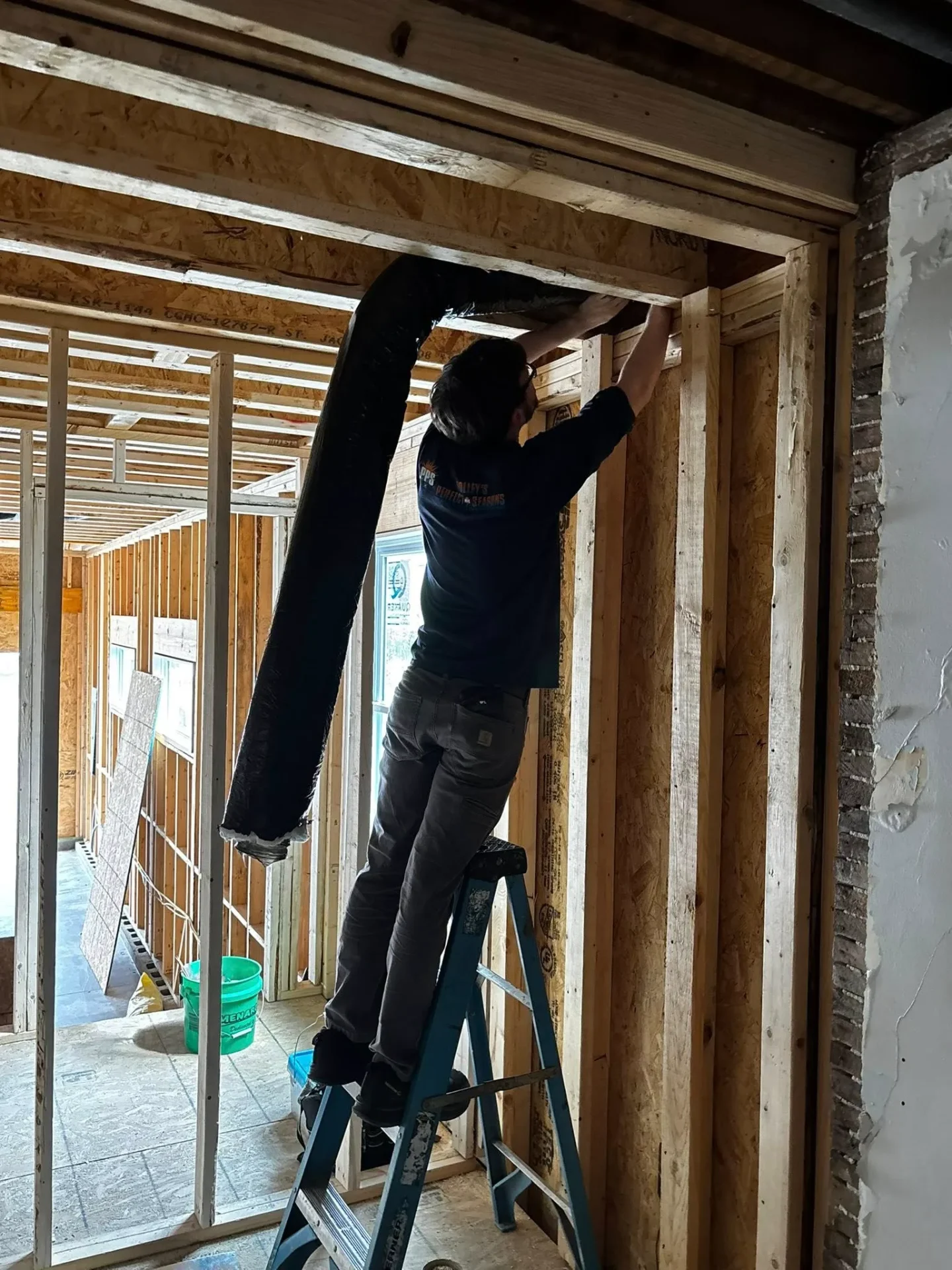 Polley's Perfect Seasons technician installing insulated flex duct in a new-construction home near Plainfield, IN