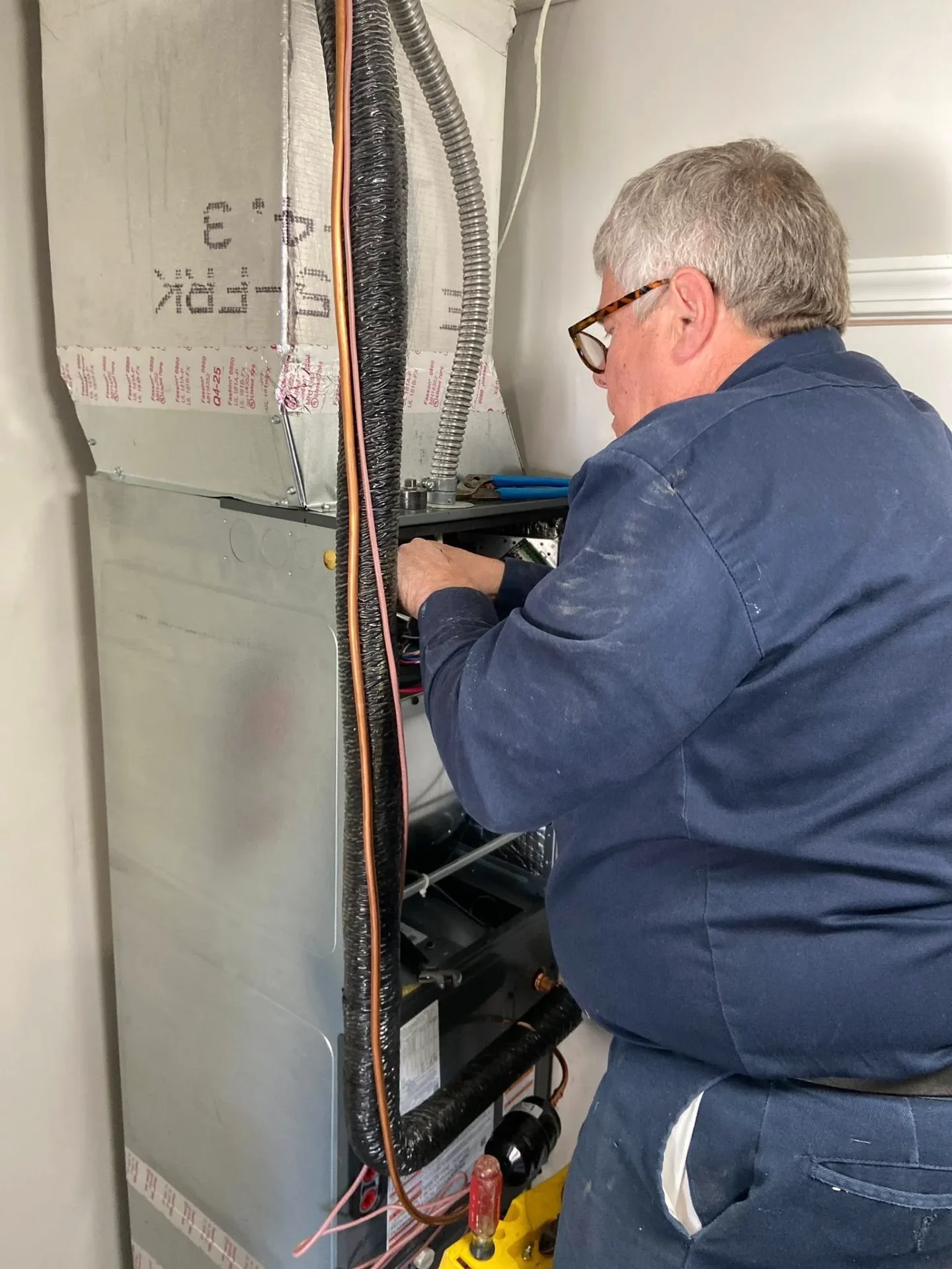 Polley's Perfect Seasons technician working on the control board inside a furnace during a Plainfield, IN repair call