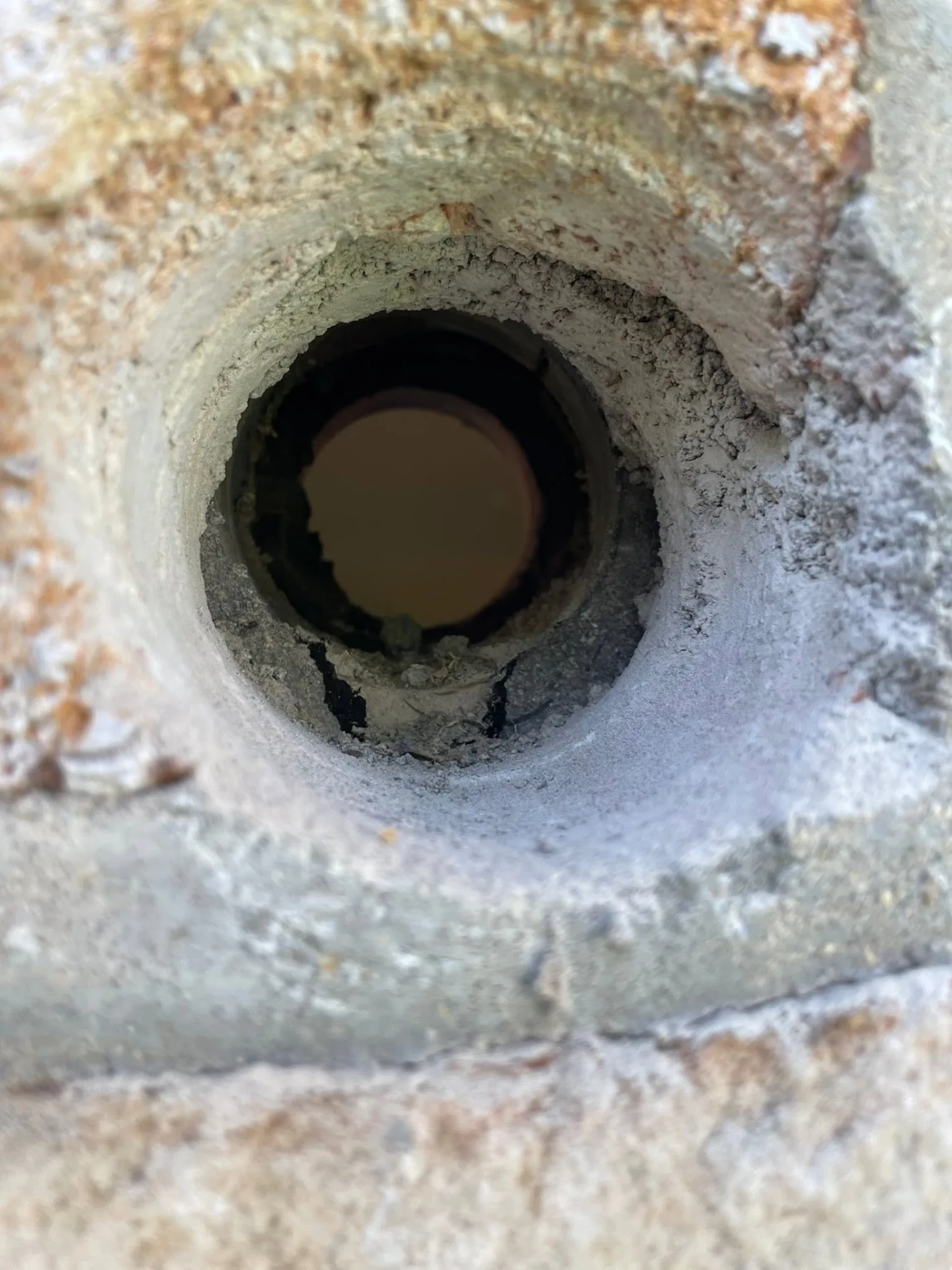 Close up of a cored wall penetration with sleeve installed for a ductless mini split refrigerant line set