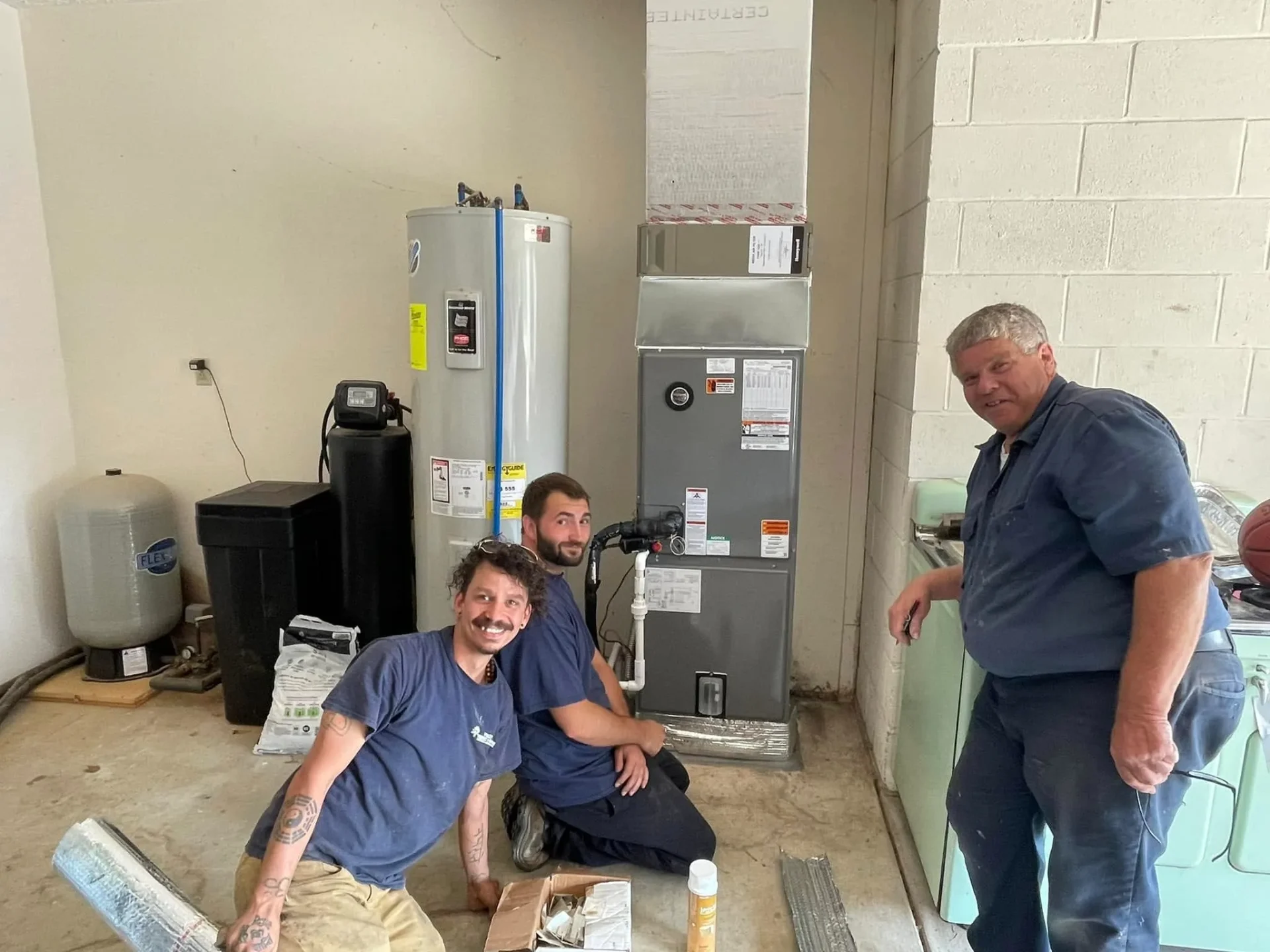 Polley's Perfect Seasons technicians next to a newly installed furnace and water heater in Plainfield, IN