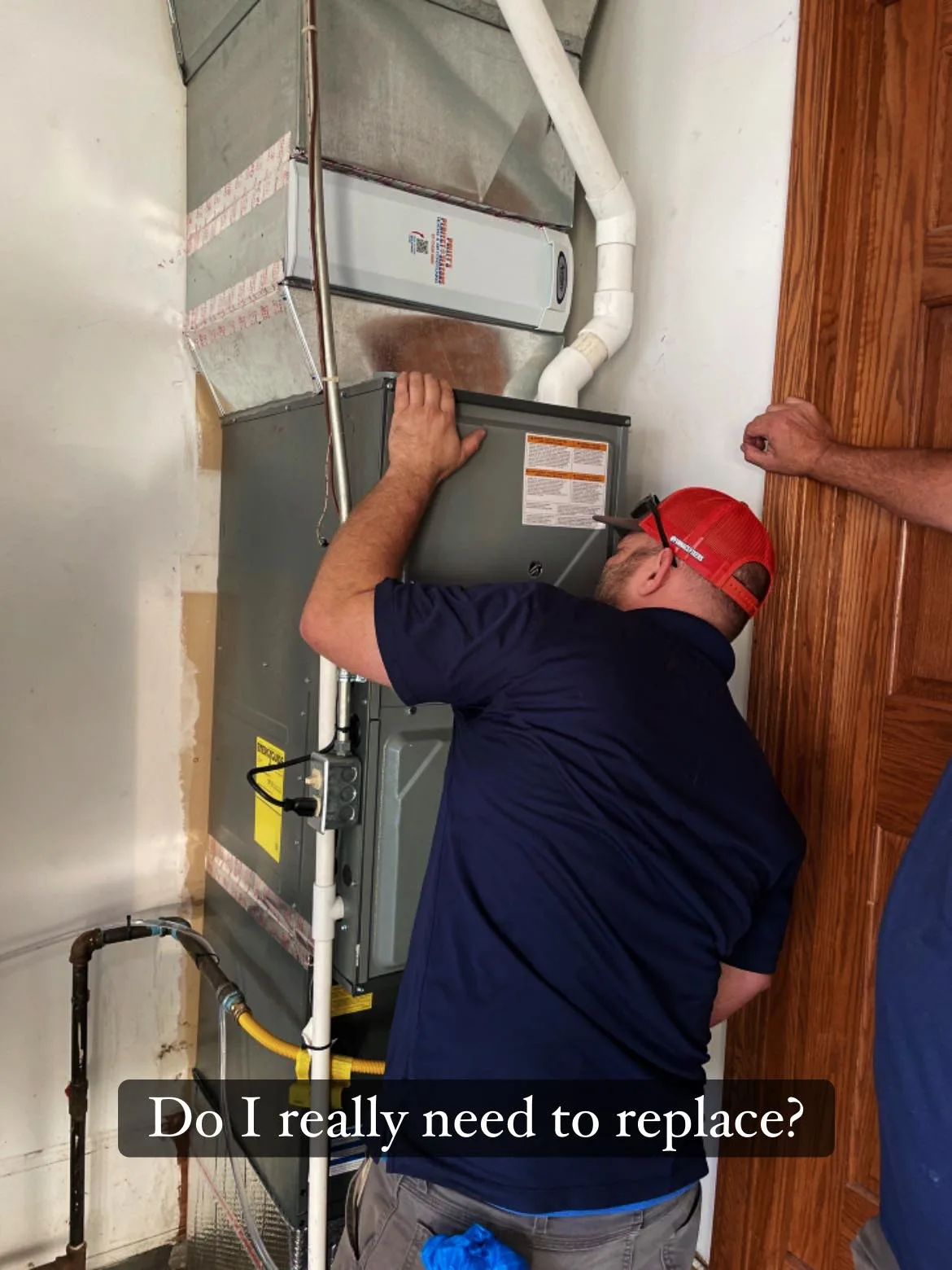 Polley's technician inspecting a furnace to diagnose repair vs replace