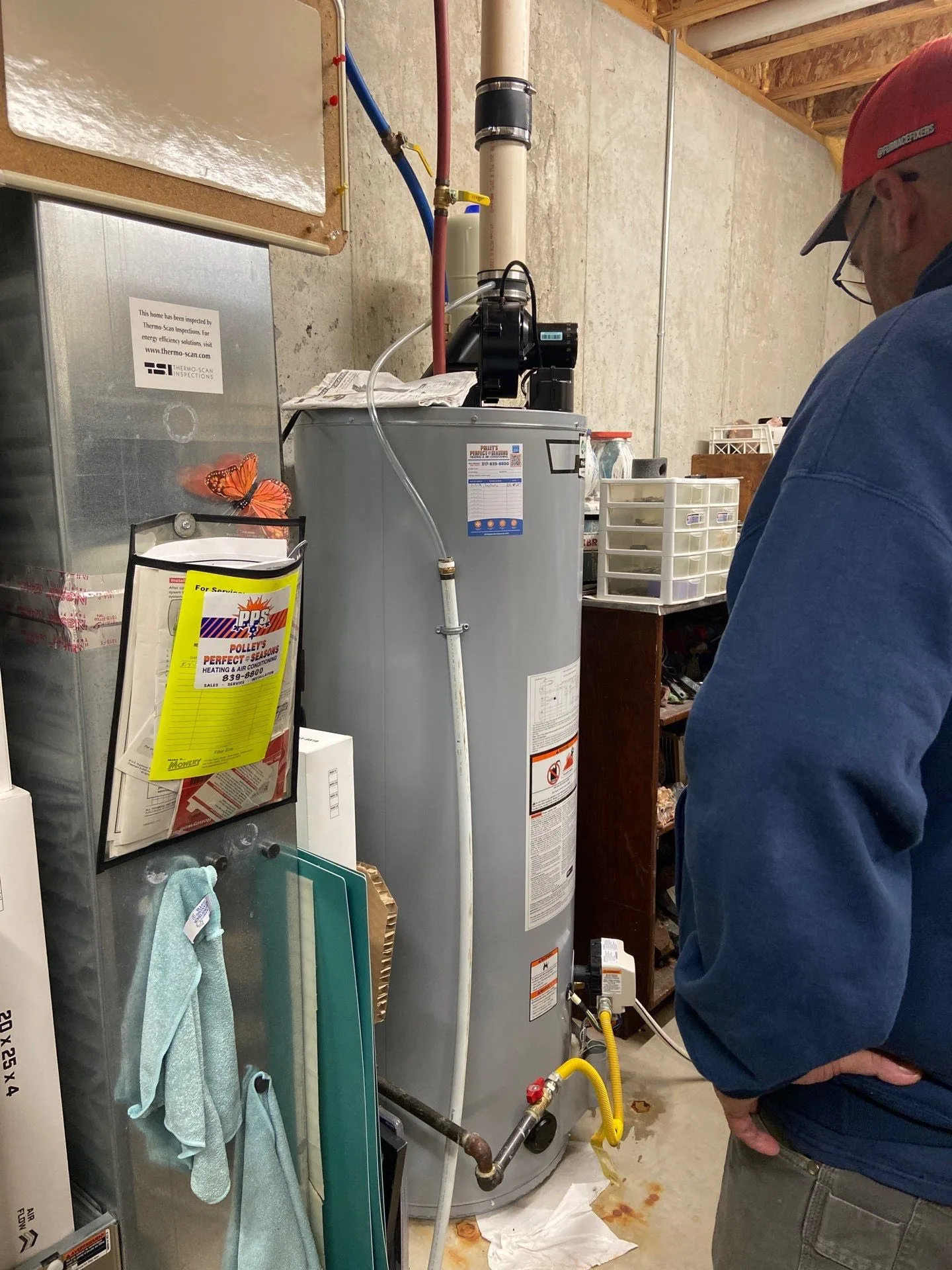 Polley's Perfect Seasons technician inspecting a newly installed gas water heater in a Plainfield, IN basement